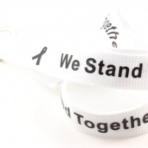 White lanyard with black "We Stand Together" text and black awareness ribbons
