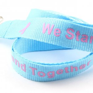 Light blue lanyard with pink "We Stand Together" text and pink awareness ribbons