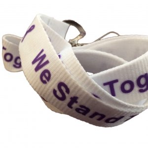 White lanyard with purple "We Stand Together" text and purple awareness ribbons